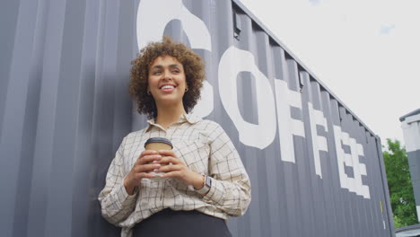 propietaria de una cafetería o negocio de distribución de pie junto al contenedor de envío