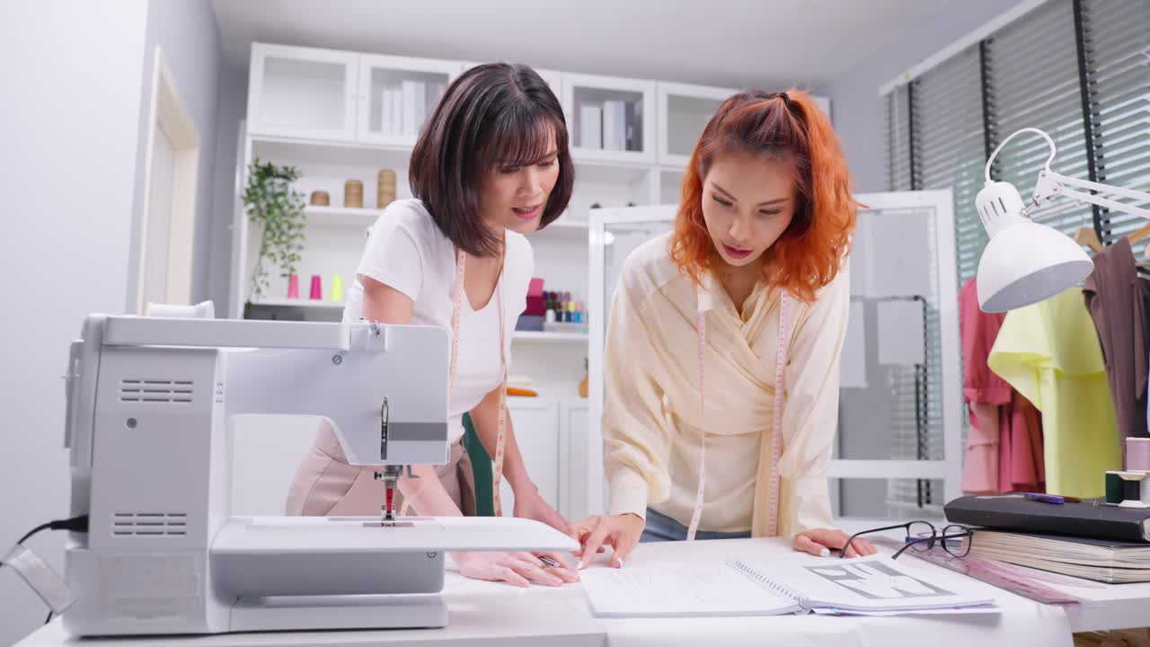 두 명의 패션 디자이너가 새로운 디자인에 협력하고 있습니다.