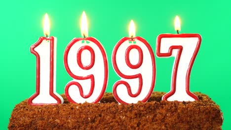 pastel con el número 1997 vela encendida fecha del siglo pasado llave de croma pantalla verde aislado