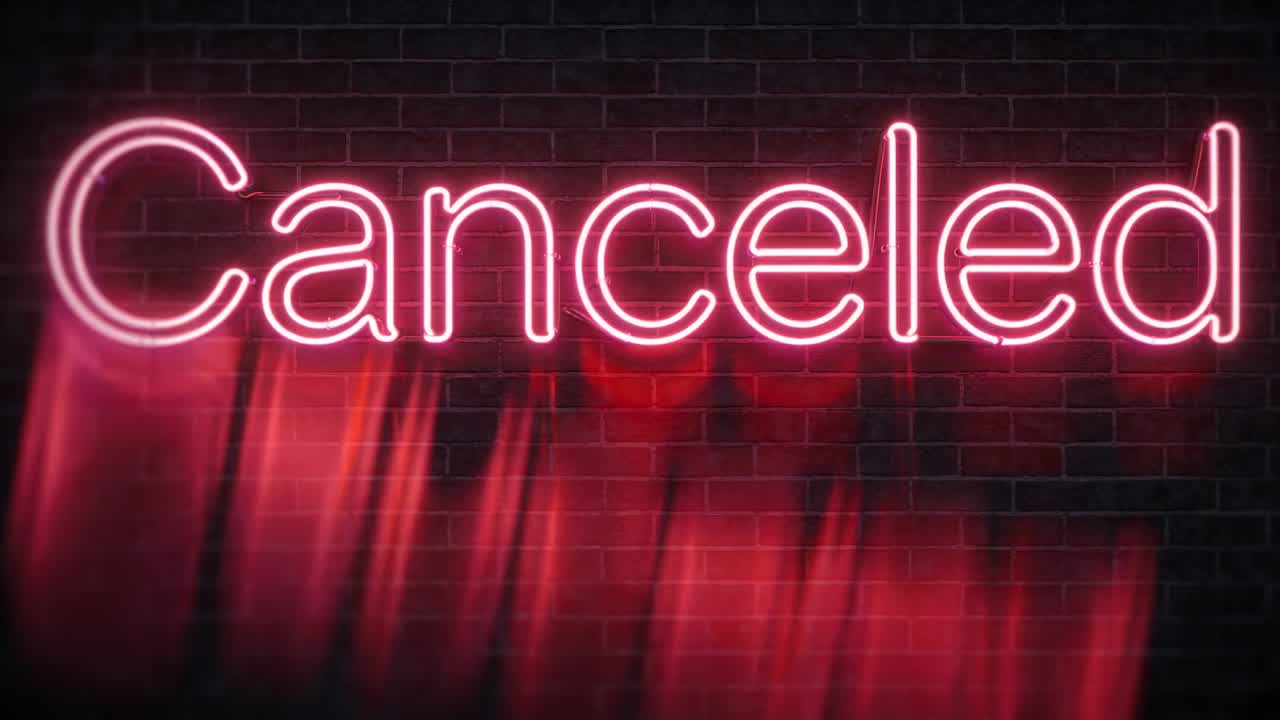 Glowing neon Canceled sign in club lighting brick wall, red pulse causing streaks making sweep