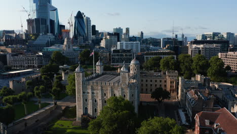 Aerial-view-of-stone-keep-White-Tower.-Backwards-revealing-modern-tall-office-buildings-in-City-financial-hub.-London,-UK