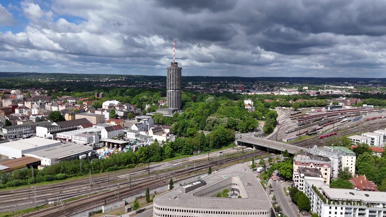 Luftbevægelse fra kirkens retning mod Hotelturm med jernbane, park og bydetaljer.