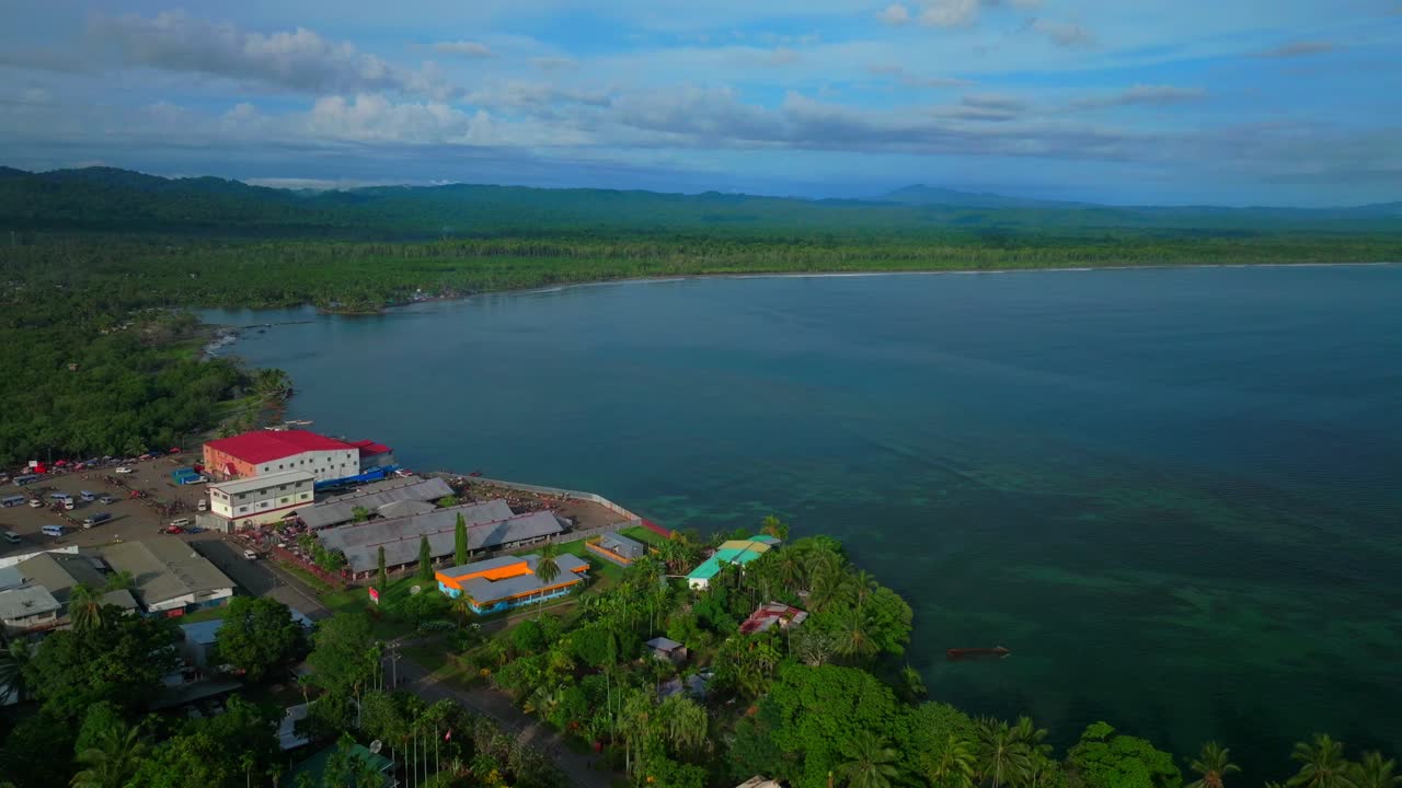 Power boat canoe driving Wewak costal town Dogreto Bay aerial drone Wewak Hill Papua New Guinea PNG East Sepik Region Province Sundaun Market Boram road summer sunny morning dry season backwards