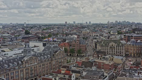 Amsterdam-Netherlands-Aerial-v16-cinematic-pull-out-shot-away-from-busy-rokin-street-overlooking-beautiful-heritage-downtown-cityscape-across-binnenstad-and-grachtengordel-neighborhoods---August-2021