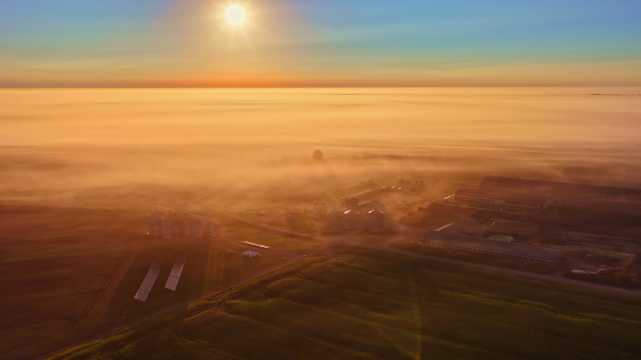 Agriculture industrial farm at sunrise, morning clouds mist fog layer, aerial drone