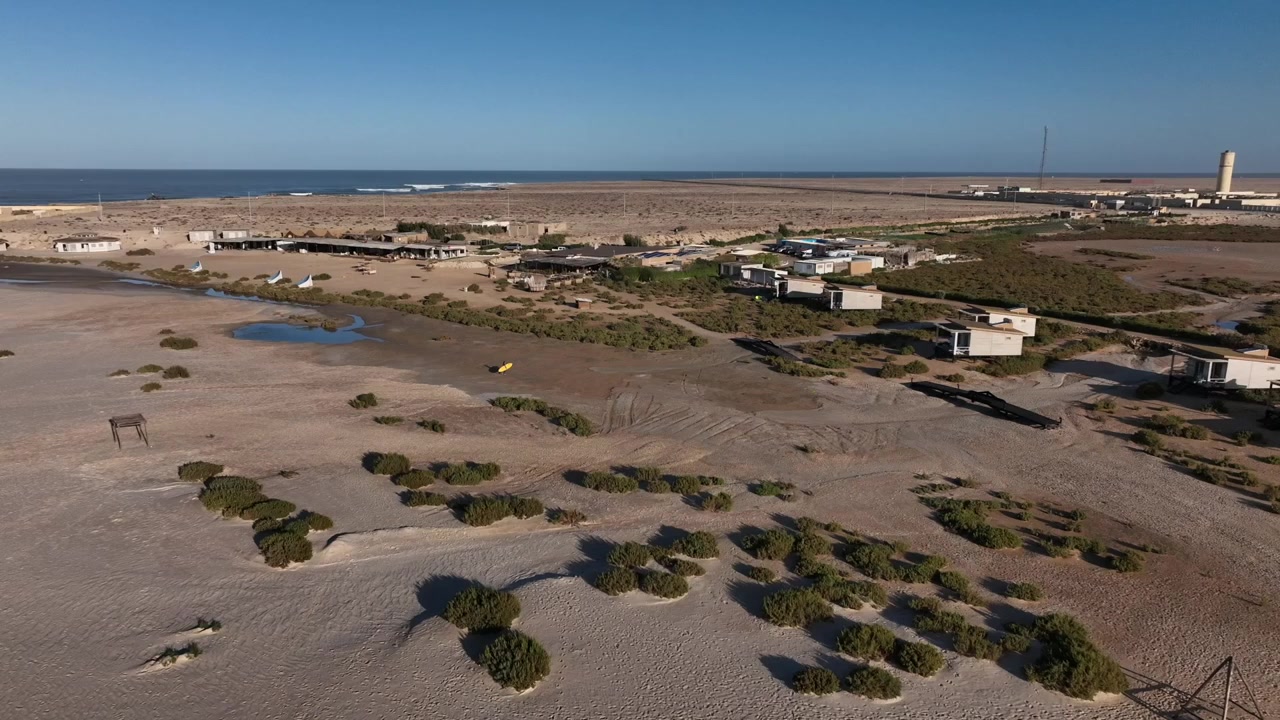 Vista aérea con dron de un paisaje desértico costero remoto cerca de la costa atlántica en Dakhla, Marruecos, ideal para proyectos de turismo, aventura y viajes.