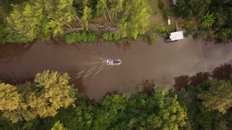 Fotografía-Cenital-De-Un-Barco-De-Turistas-Cruzando-Un-Pequeño-Arroyo-En-La-Selva-Amazónica