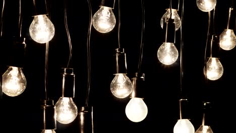 las bombillas eléctricas están conectadas en una guirnalda afuera por la noche