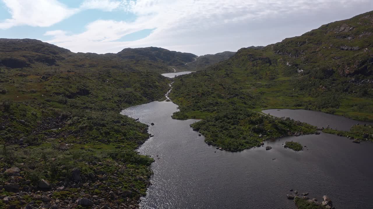 Lush Norwegian landscape with winding rivers, rocky hills, and serene waters
