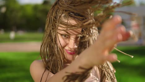 una hermosa joven con pajas bailando en un parque. una hermosa mujer escuchando música y bailando durante un día soleado