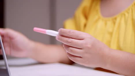 an expectant woman is holding a pregnancy test while counting the days and months prior to her possible delivery due date