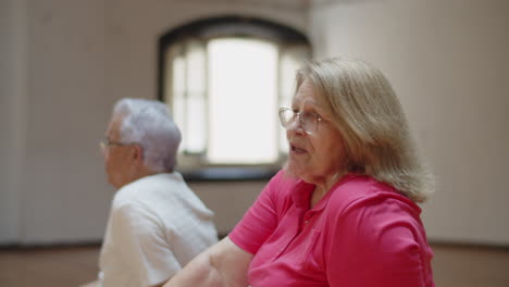 senior woman talking with friends after dance class in studio