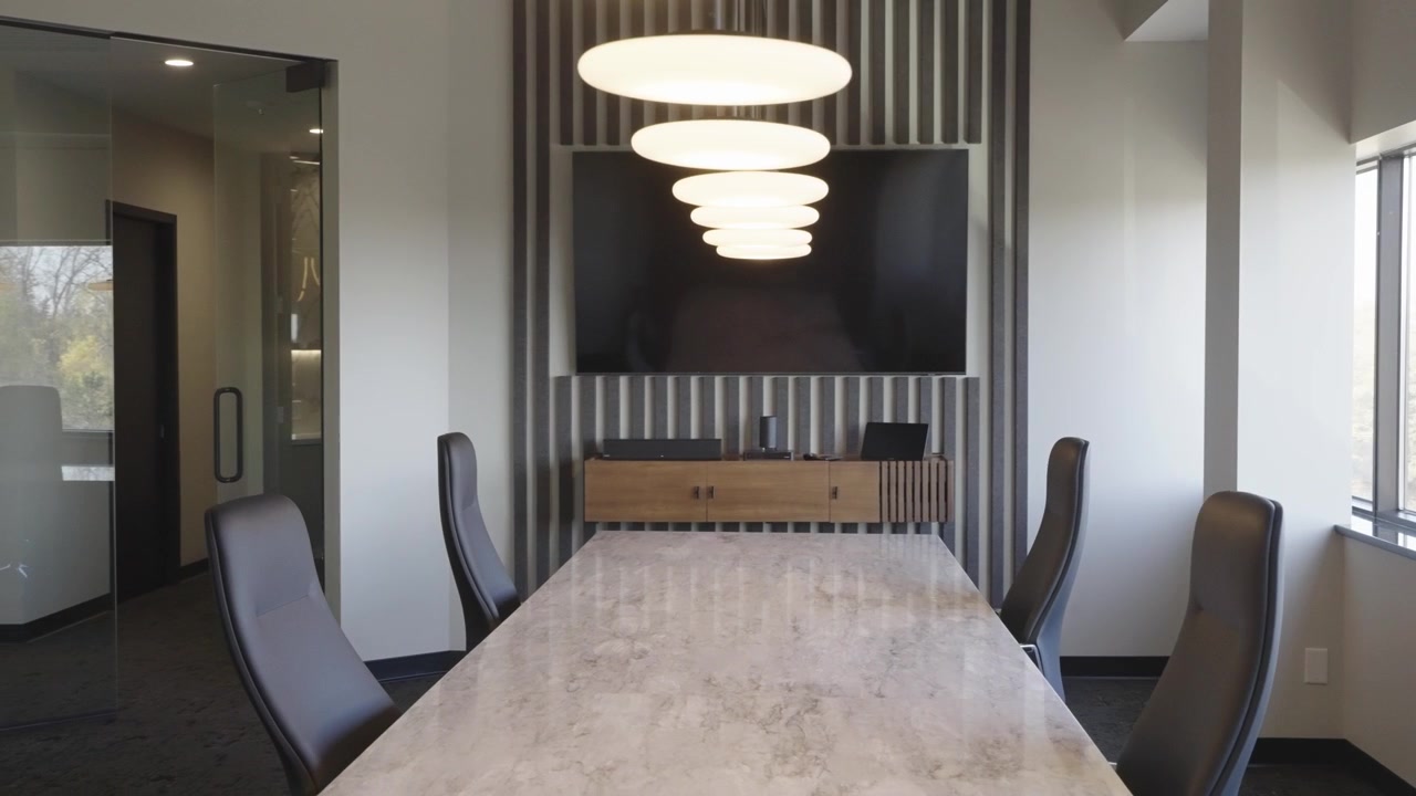 Elegante sala conferenze con sedie moderne, tavolo lucido e luce naturale.