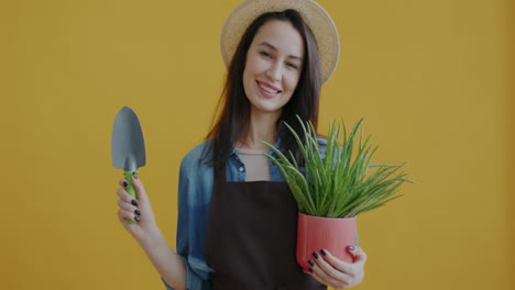 woman holding aloe vera plant and gardening tools
