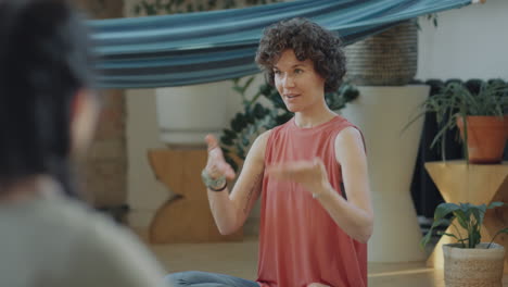 woman leading a wellness or yoga session indoors
