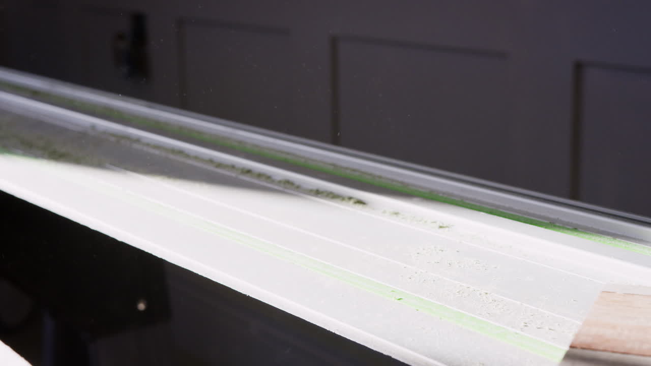 плотник сдувает пыль с пиломатериалов