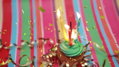 Animation-Von-Goldenem-Konfetti,-Das-über-Brennende-Kerzen-Und-Wunderkerzen-Auf-Einem-Geburtstags-Cupcake-Fällt