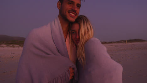 caucasian couple enjoying time at the beach during the sunset