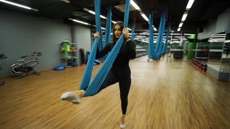 mujer atractiva haciendo ejercicios de estiramiento de aero yoga en hamacas en un estudio de fitness. estilo de vida saludable para mujeres. gimnasio de entrenamiento