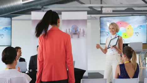 female speaker presenting an award to a young woman at a business conference