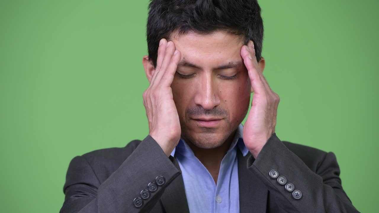 Stressed Hispanic businessman having headache