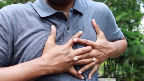 Young-man-suffering-pain-in-heart-and-holding-chest-with-hand