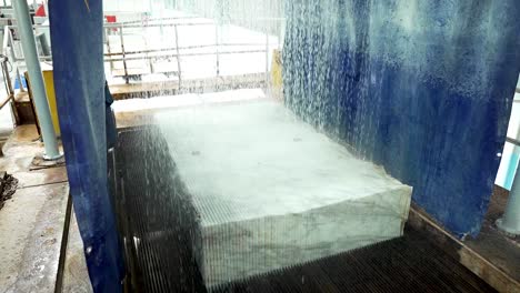 wide shot of marble block cutting with water jets in stone processing factory. industrial marble slab slicing process. wet stone saw machine, factory production, heavy machinery, marble cutting video