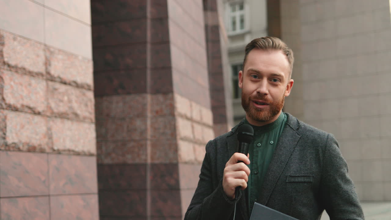 가을에 거리에서 마이크에 대고 말하는 백인 남성 기자 웃고