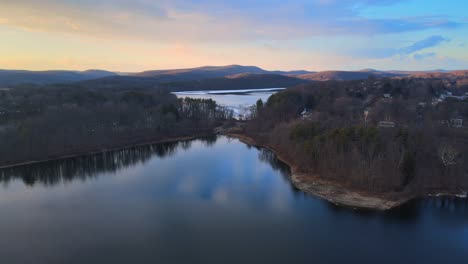 aerial drone footage of lakes, hills, mountains, and forests during sunset in the appalachian mountain during winter