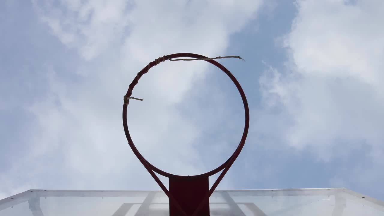 un aro de baloncesto con un fondo de nubes en movimiento