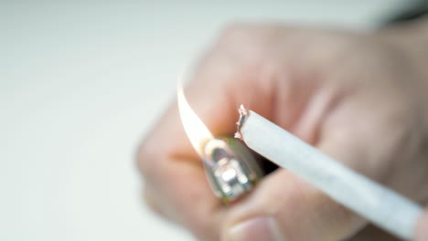 singeing end of cbd rolled cannabis cigarette close up