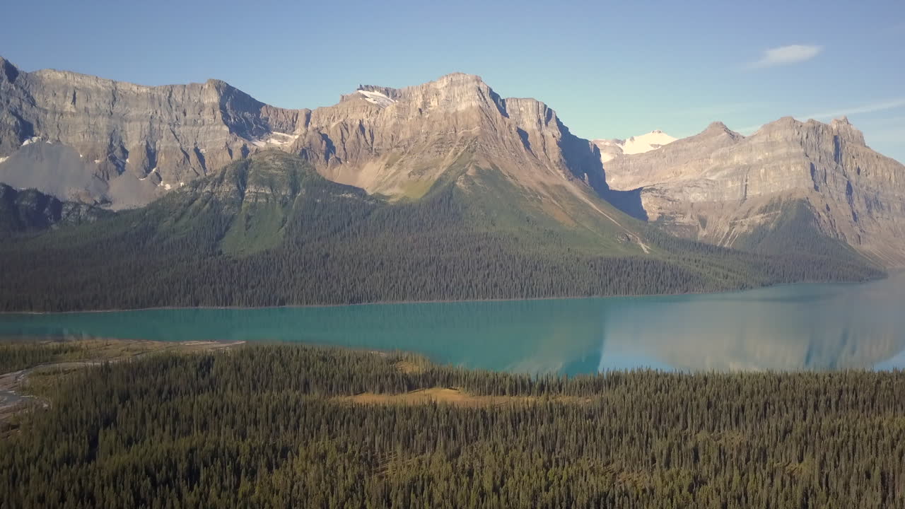 Aerial reveal, Pulpit Peak and surrounding Rockies reflecting in the calm waters of Hector Lake, Alberta Canada