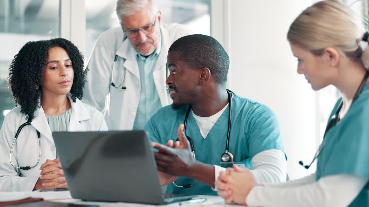Medical team collaborating on patient care using a laptop
