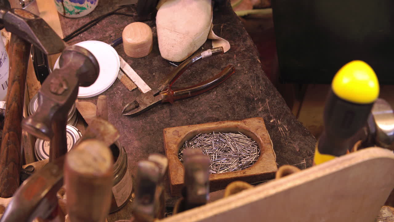 Close Up Of Shoemaker's Work Bench With Tools And Pins