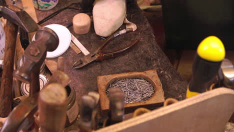 Close-Up-Of-Shoemaker's-Work-Bench-With-Tools-And-Pins