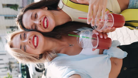 two happy friends enjoying drinks outside