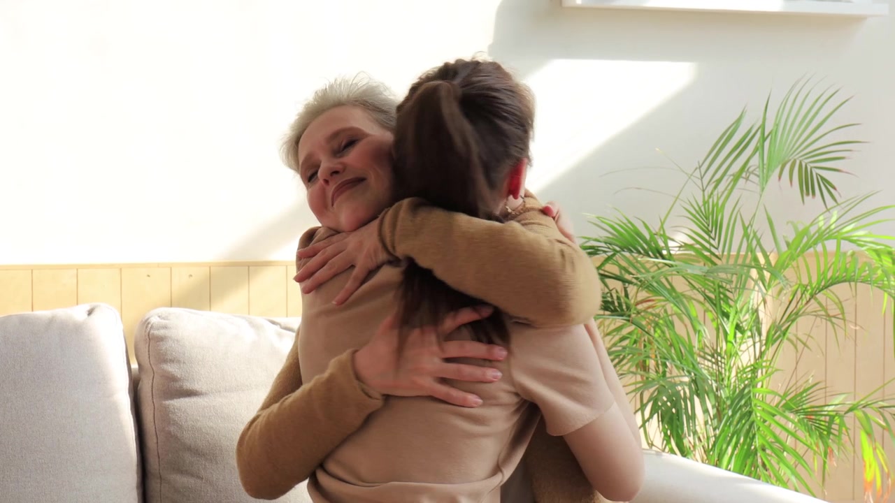 Madre anziana felice e figlia adulta che si abbracciano in un caldo abbraccio