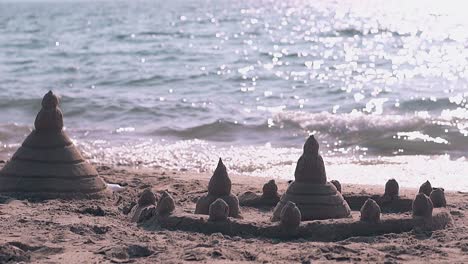 castle with towers made from wet sand on beach slow motion