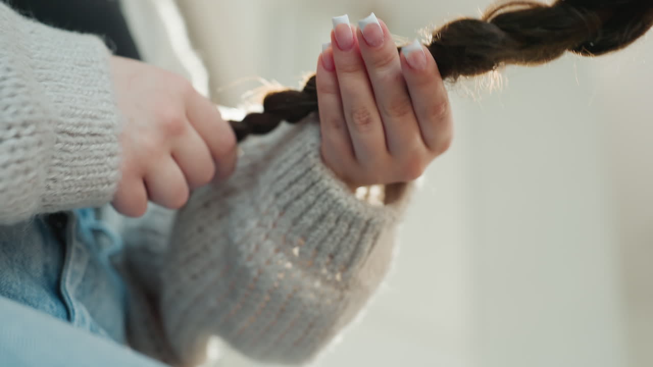 Caucasian Hands Holding Sunlit Braided Hair Friend Performing Gentle Care Ritual, Soft Evening Glow Through Window, Knit Sleeve, Tender Motion, Calming Selfcare Mood, Intimate Lifestyle Moment