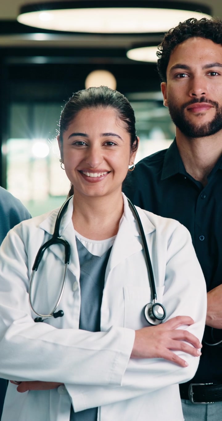 Diverse Group of Medical Professionals Smiling in Hospital Corridor