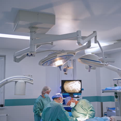 teamwork of surgeons in modern operating room. contemporary equipment in clinic. professional doctors in medical uniform perform a surgery.