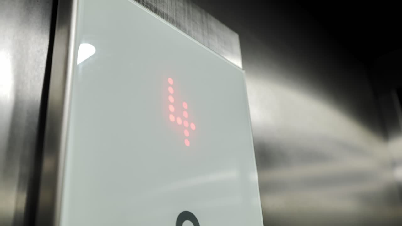 Close up, elevator control panel showing illuminated floor display moving upward