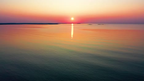 Aerial-Drone-View-of-Sunrise-Colors-Reflecting-off-Ocean-Waves-Along-the-Coastline