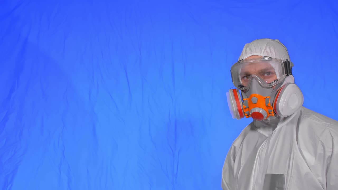 인공호흡기에서 바이러스학자 과학자는 태블릿 컴퓨터에 스타일러스를 사용하여 글을 쓴다. 보호 의료 마스크를 착용한 남자. 크로마 키 파란색.