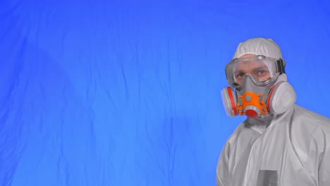científico virólogo en respirador hace escribir en una tableta con lápiz. hombre con máscara médica de protección. clave de croma azul.