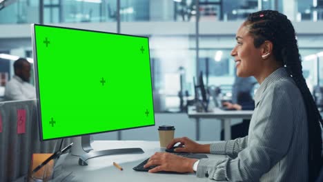 oficina corporativa diversa: hermosa técnica informática negra que utiliza una computadora de escritorio con pantalla clave de croma verde. ingeniero de software creativo que trabaja en el marketing y el desarrollo de proyectos de comercio electrónico