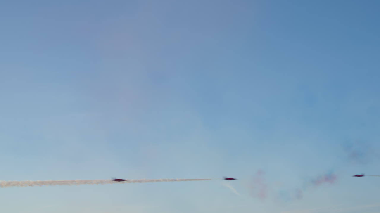 Jetfly, der flyver i formation og efterlader røgstriber på en blå himmel