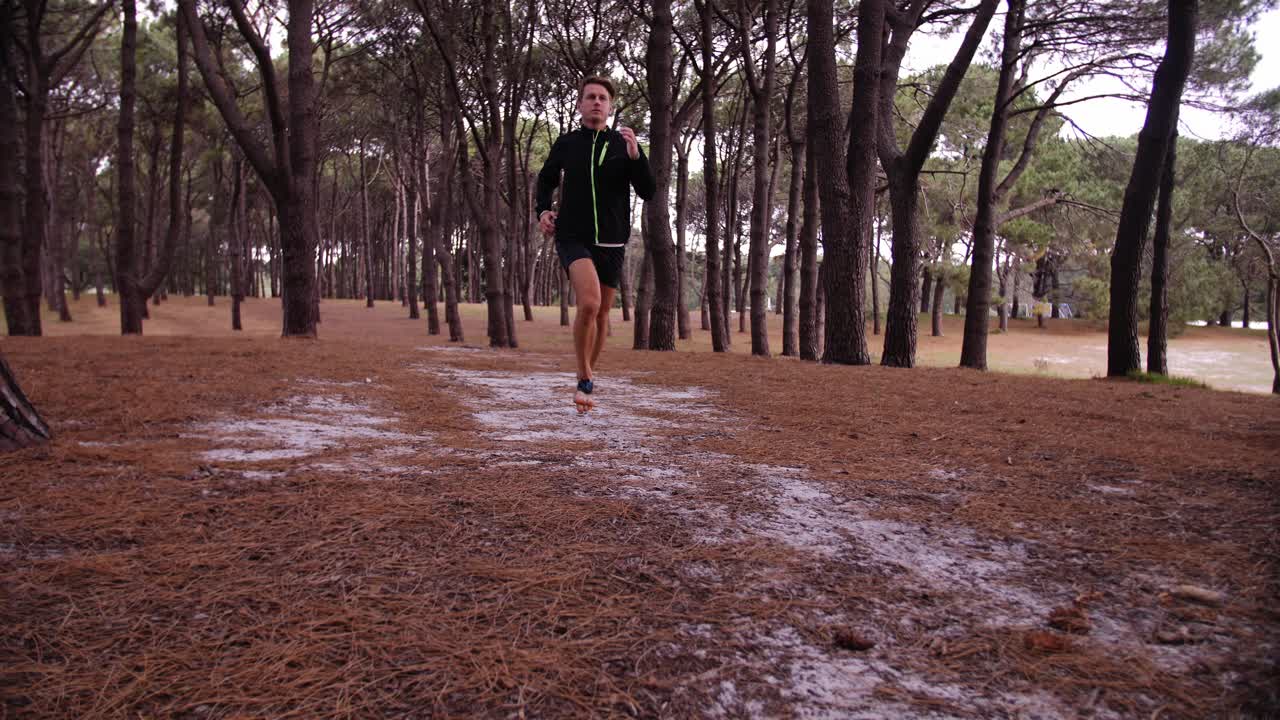 Man jogging slowmo with Pine Tree Forest Surrounding Him