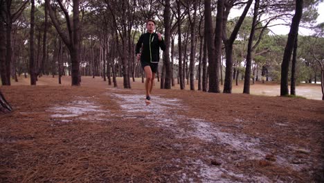 man jogging slowmo with pine tree forest surrounding him