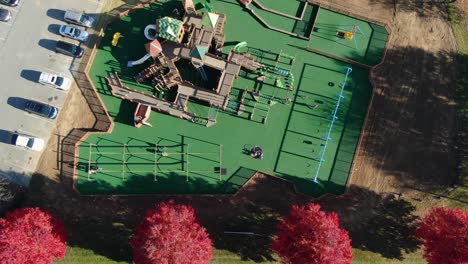 top down birdseye aerial of children on playground equipment at park during sunny autumn day